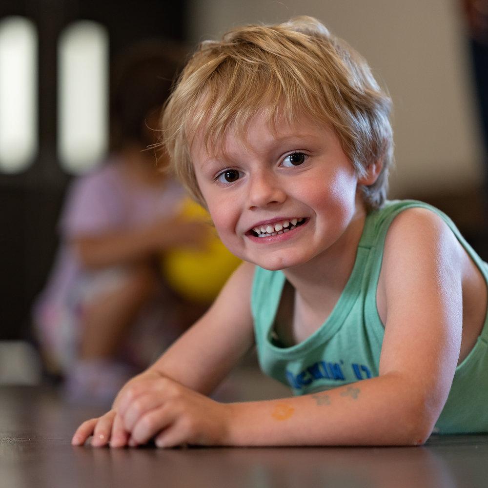 Young boy smiling on the floor at Victory Academy, a Christian daycare in Raleigh NC
